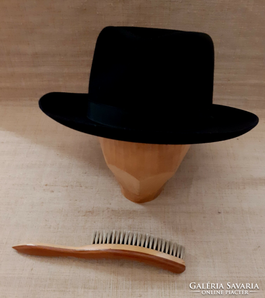 A well-maintained black branded hat with a horsehair hat brush with a wooden handle