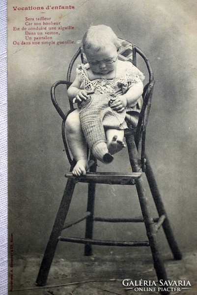 Antique humorous photo postcard of a baby in a high chair as an aunt repairing clothes