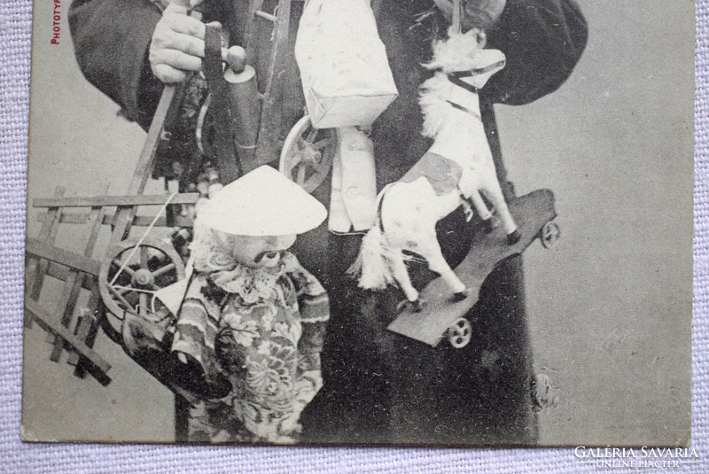 Antik humoros Szilveszteri fotó képeslap cilinderes úriember rengeteg ajándékkal csokor baba hintaló