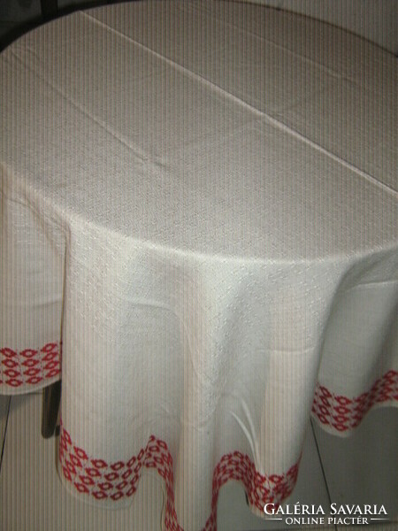 Elegant filigree woven tablecloth with a beautiful red patterned edge