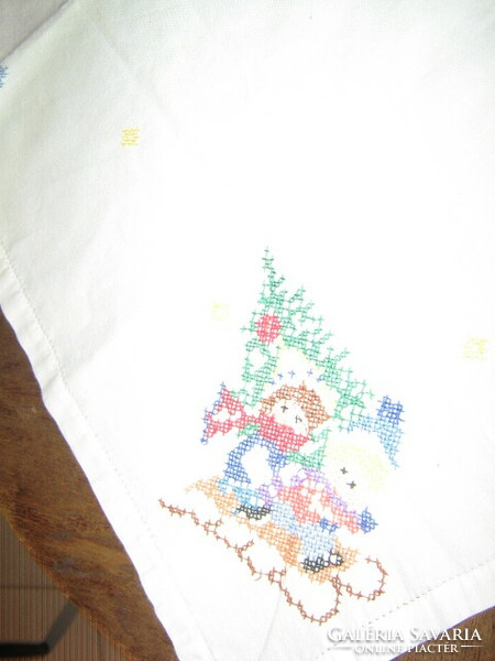 Hand-embroidered tablecloth with children sledding with a beautiful winter pine tree