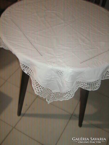 Beautiful azure hand-embroidered white filigree tablecloth with a crocheted edge