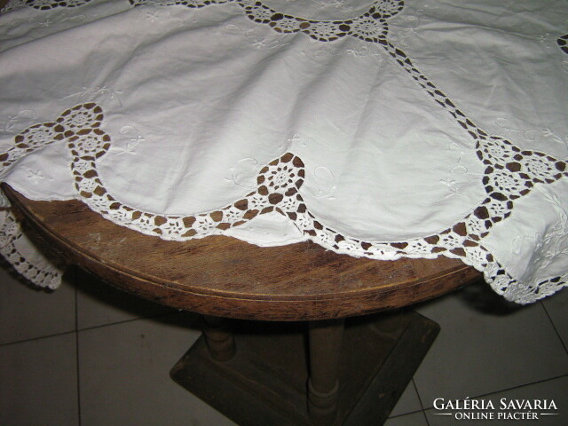 A dreamy white madeira embroidered tablecloth with a hand-crocheted flower pattern edge and inlay