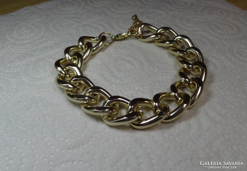 Cuban gold-colored bracelet with rounded eyes, but where the ends meet, it is unisex.