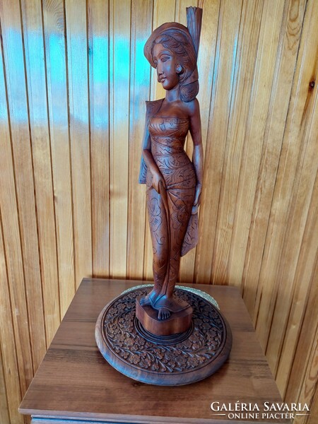 A large, heavy Indian female statue carved from wood