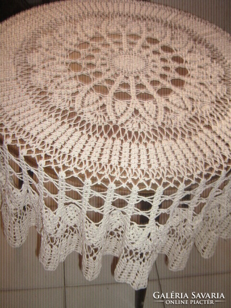 A beautiful off-white hand-crocheted round tablecloth