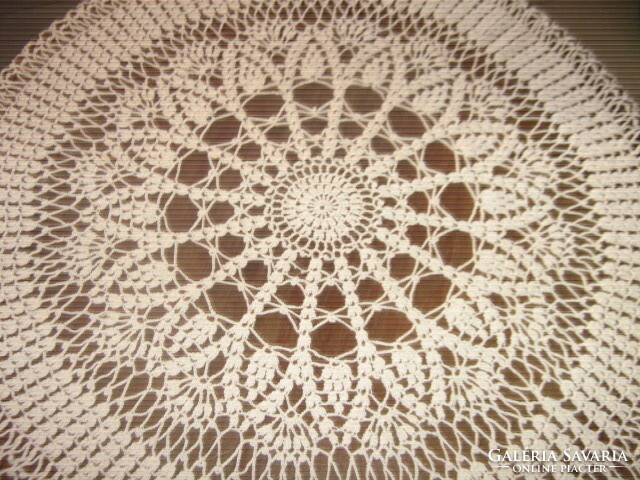 A beautiful off-white hand-crocheted round tablecloth