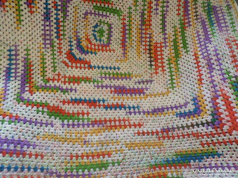 Colorful hand crocheted sofa or armchair cover.