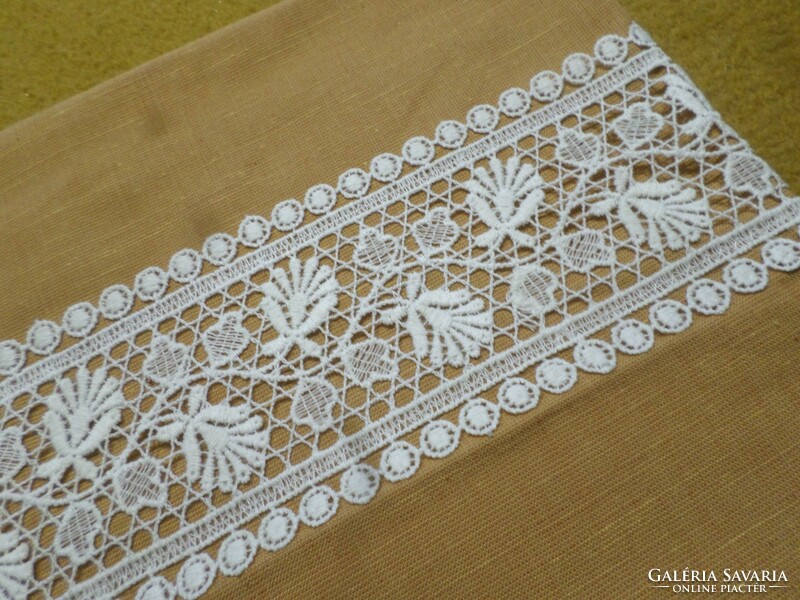 Linen cushion cover with lace inserts.