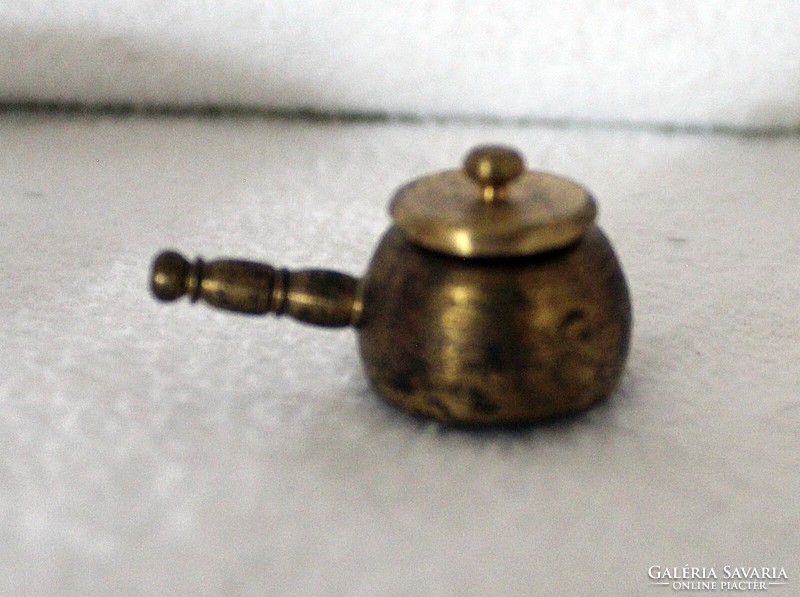A miniature copper bowl with a handle