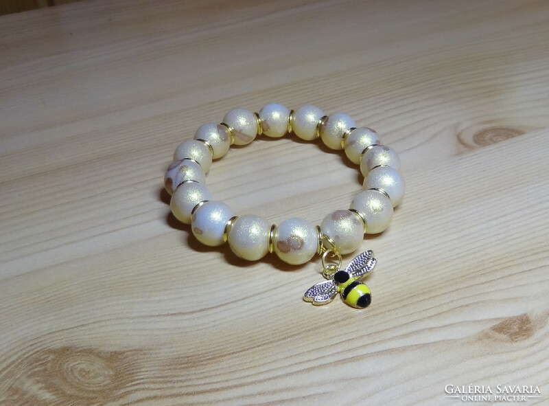 Gold-plated quality glass pearl bracelet on a white background, fire enamel with bee, gold spacers