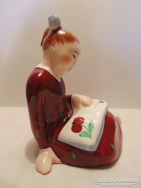 Little girl reading Bodrogkeresztúr ceramics