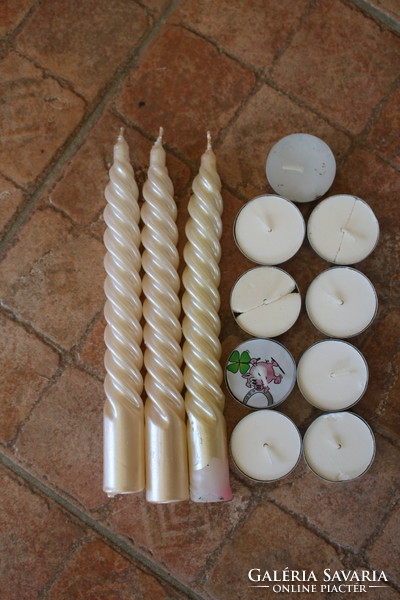 12 white candles, one of which has a lucky pig on it