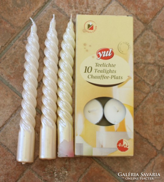 12 white candles, one of which has a lucky pig on it