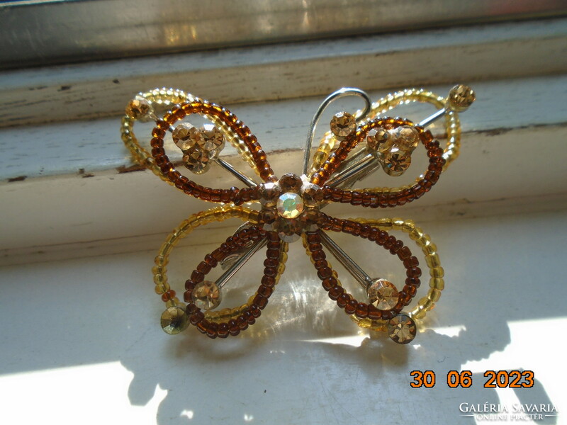 Butterfly brooch made of iridescent cut stones and small amber pearls