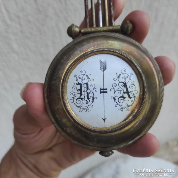 Antique wall clock pendulum made of copper enamel center.