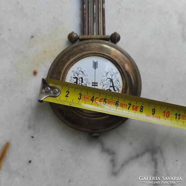 Antique wall clock pendulum made of copper enamel center.