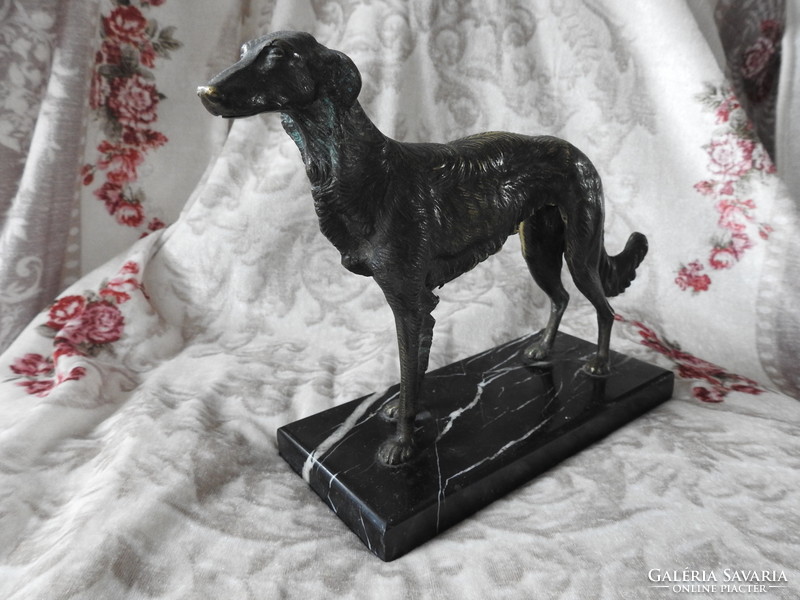 Bronze greyhound dog on a marble pedestal