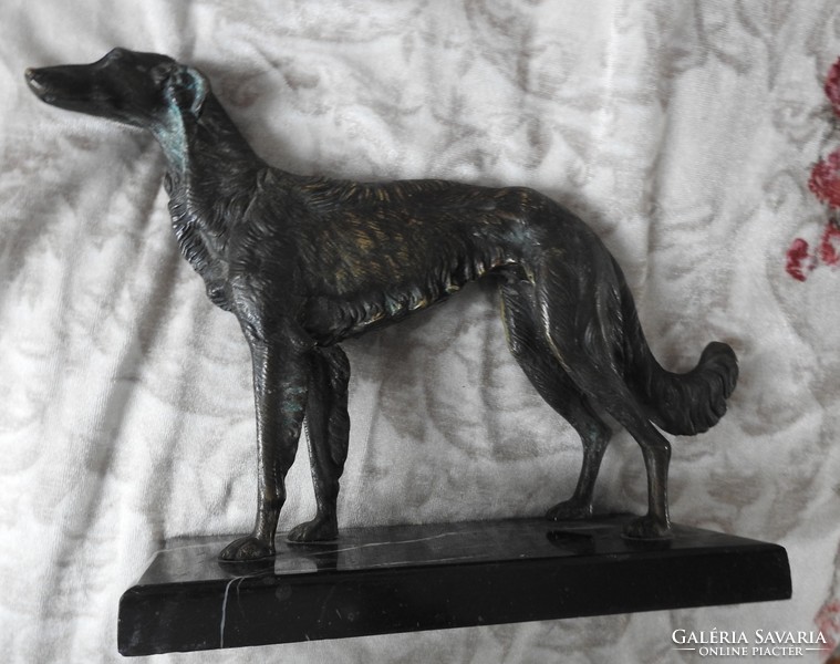 Bronze greyhound dog on a marble pedestal