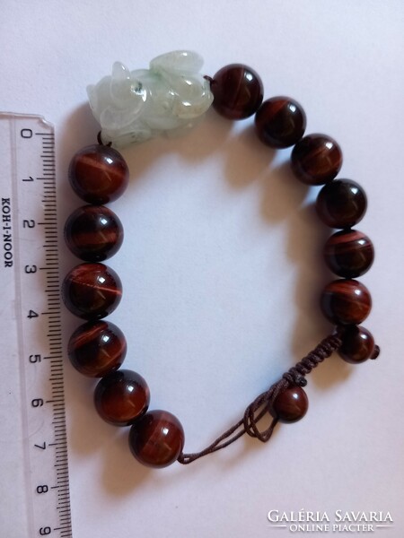 A beautiful bracelet decorated with a large tiger's eye and a carved jade dragon