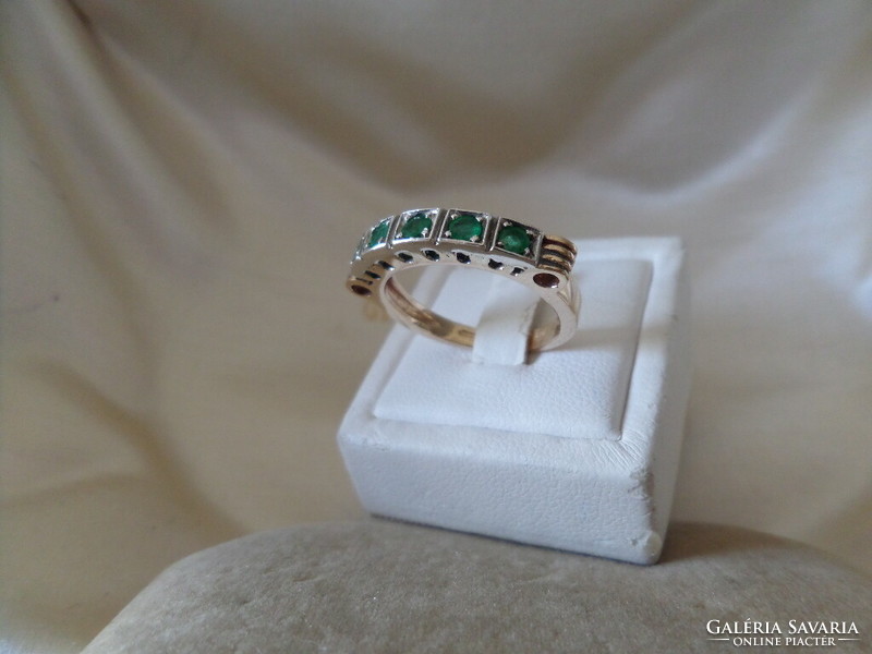 Gold row ring with emeralds