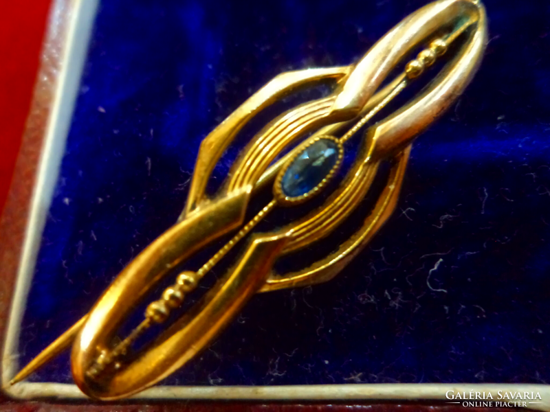 Old brooch gold-plated, decorated with a beautifully polished blue stone