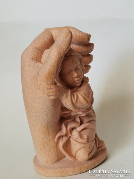 Carved wooden statue: a protective hand with a small child