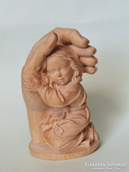 Carved wooden statue: a protective hand with a small child