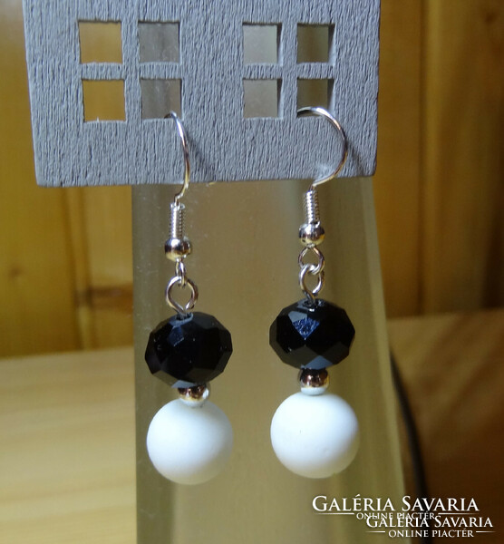 Earrings made of 8 mm pearls with black polished crystal beads and white rubber coating.