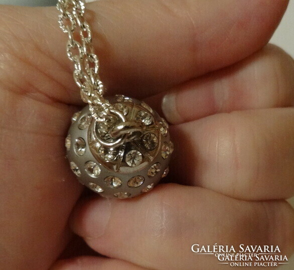 Silver-colored spherical pendant richly studded with zirconia stones, very showy.