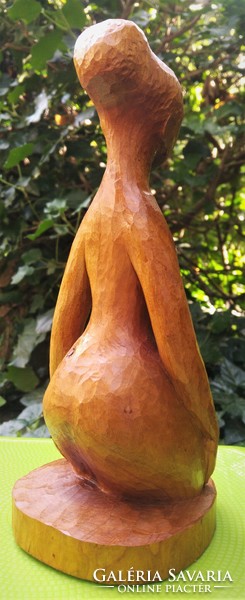 Carved wooden seated female nude