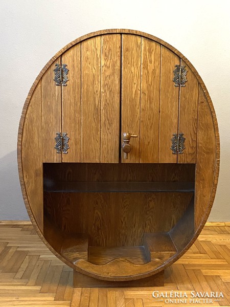 A barrel-shaped cabinet wine cellar can be decorated with glass holders and serving furniture