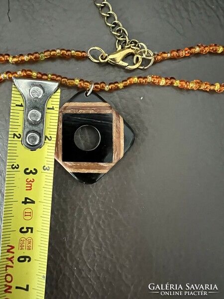 Inlaid wooden pendant on a glass bead necklace