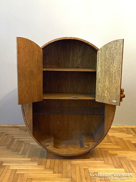 A barrel-shaped cabinet wine cellar can be decorated with glass holders and serving furniture
