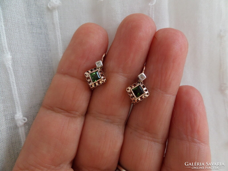 A pair of gold earrings with green tourmalines and brils