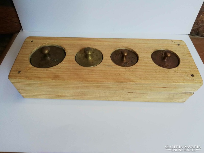 Copper scale weights in a wooden holder