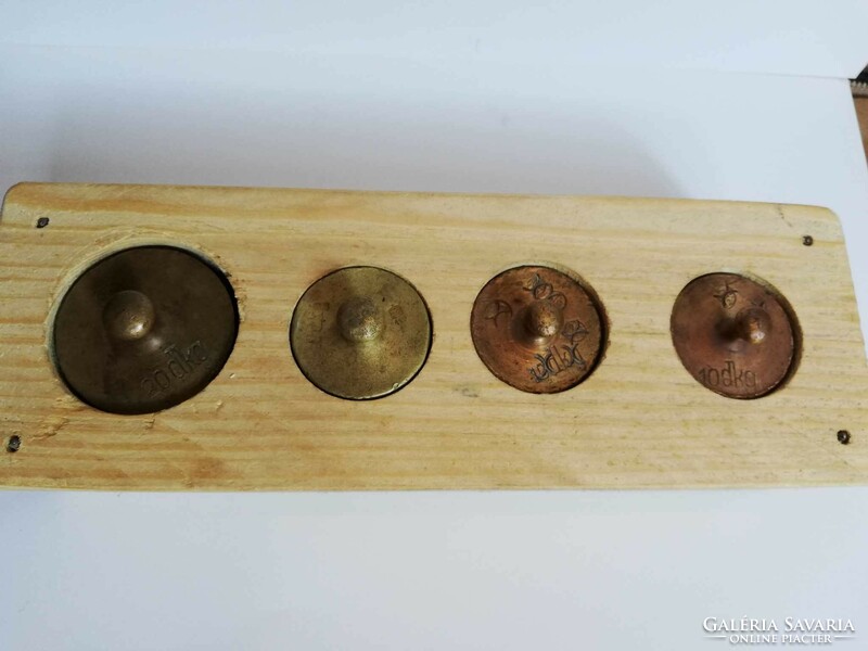Copper scale weights in a wooden holder
