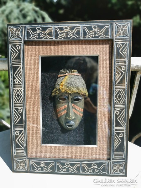 African wooden mask in a carved frame