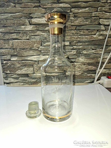 Polished, gilded decoration of glass liquor bottle