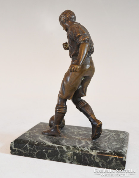 Bronze football player statue on a marble plinth