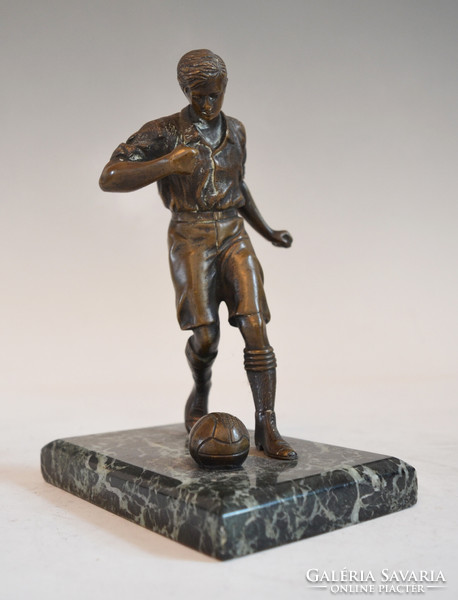 Bronze football player statue on a marble plinth