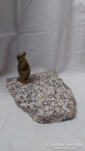Copper penguin statue on a marble slab