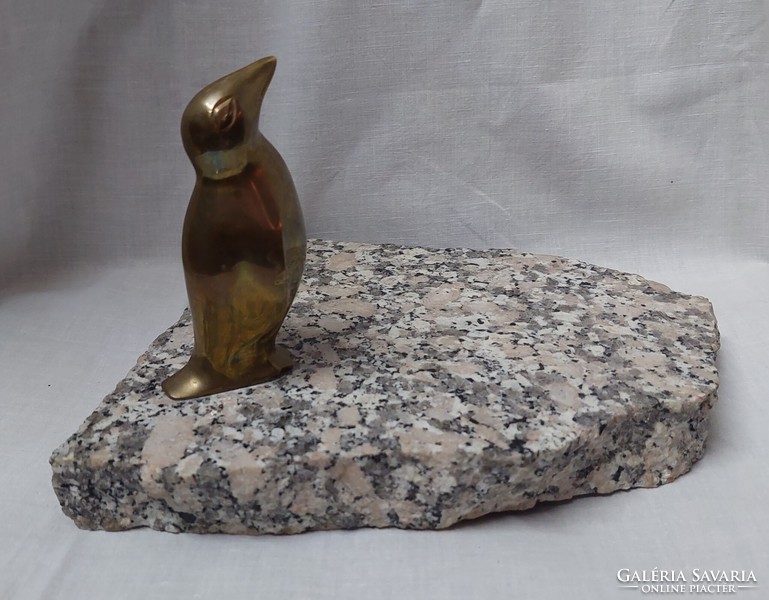 Copper penguin statue on a marble slab