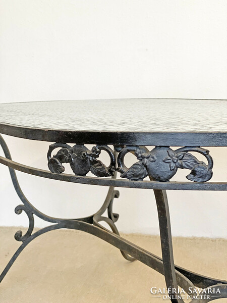 Graceful wrought iron dining table with glass top