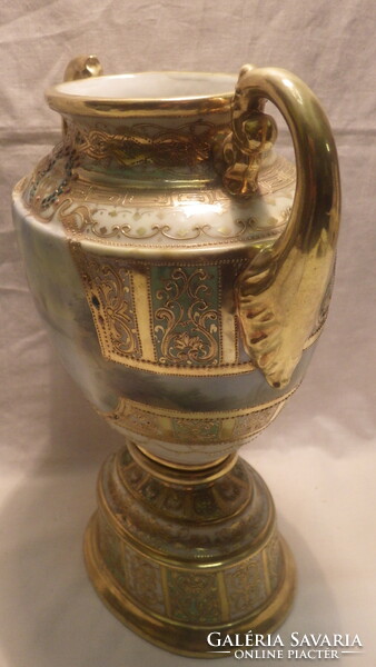 An antique porcelain vase with a richly decorated painting in sumptuous gold