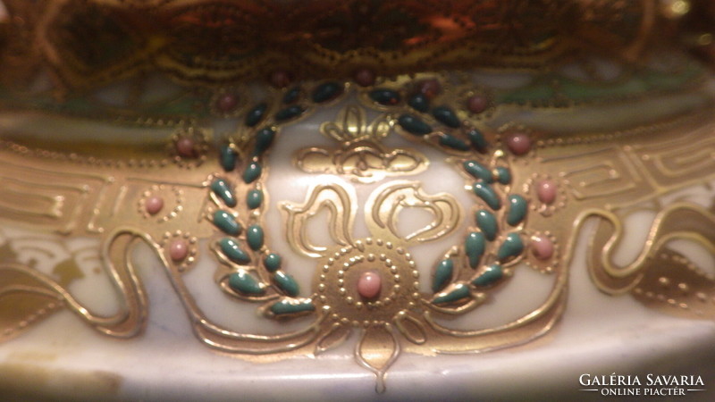 An antique porcelain vase with a richly decorated painting in sumptuous gold