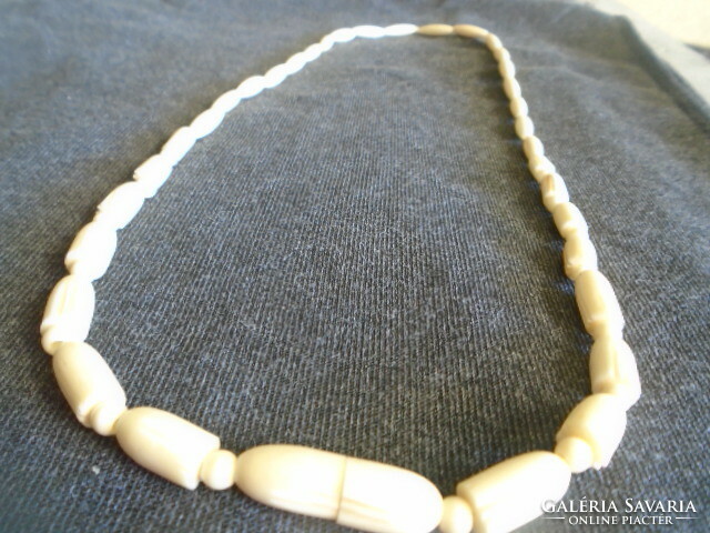 Old, exotic bone art deco necklace. African handcrafted jewelry from the 1960s in mature egg color
