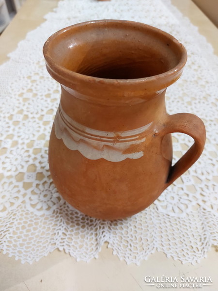 An old mug, a glazed earthenware pot, a jar, a jug, a tumbler