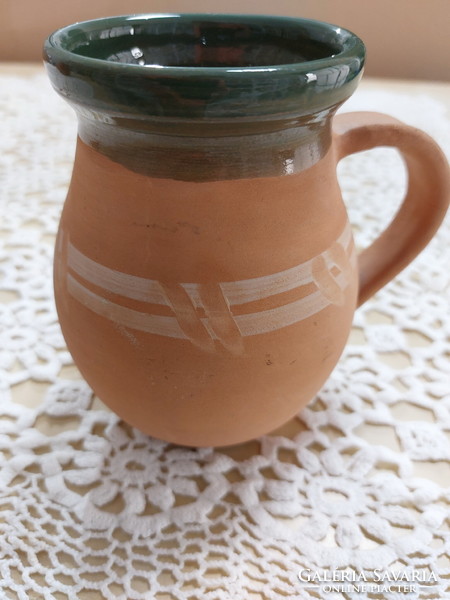 An old mug, a glazed earthenware pot, a jar, a jug, a tumbler