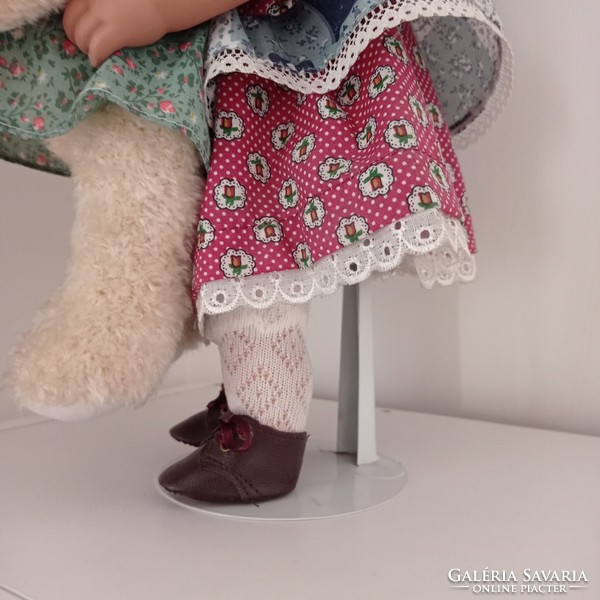 Marked porcelain doll with teddy bear, stand 42 cm high